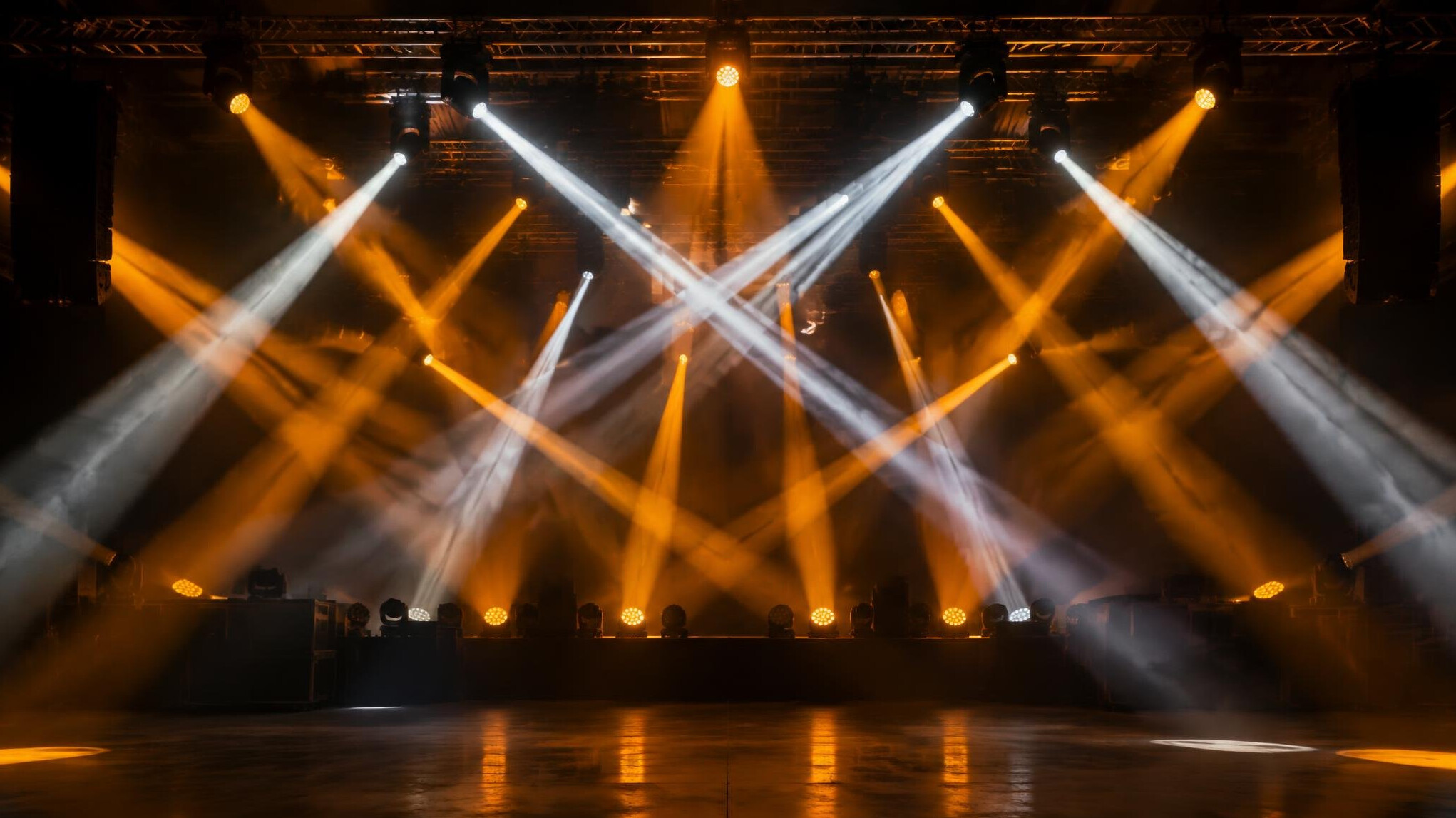 Stage lights beams over a dark venue